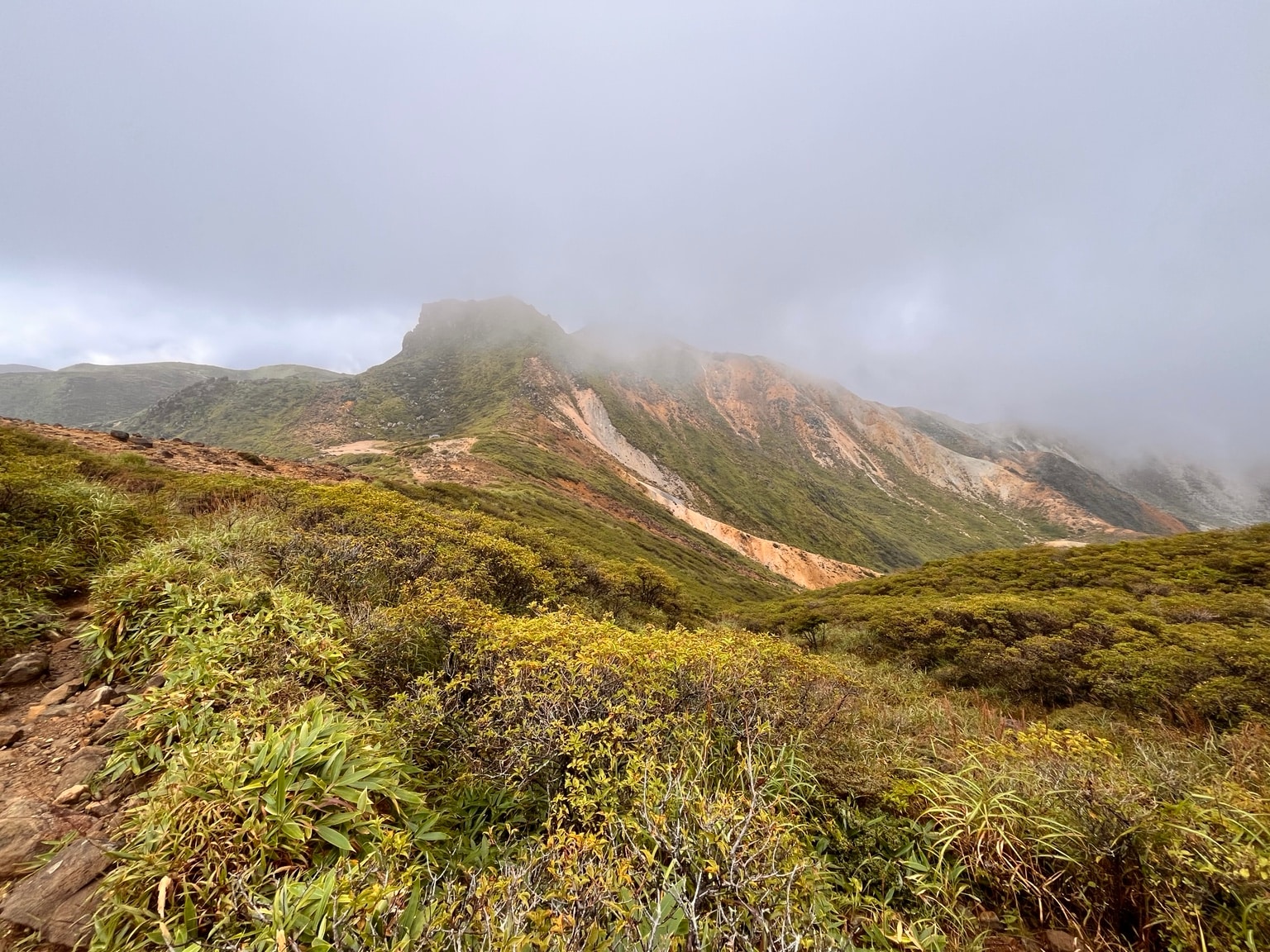 雲の切れ間から見えたくじゅう連山の岩肌と草地